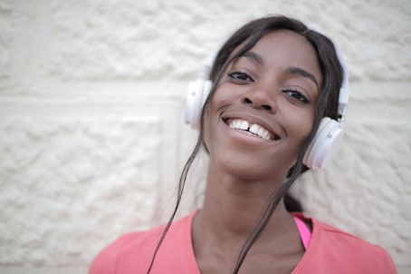 Happy African American female listening to music  © Andrea_Piacquadio 